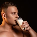 Junger blonder Mann trinkt Glas mit Sperma