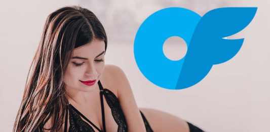 Frau am Handy in schwarzen Dessous liegt auf dem Bett mit Onlyfans Logo