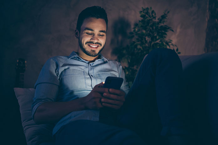 Mann lächelt am Smartphone